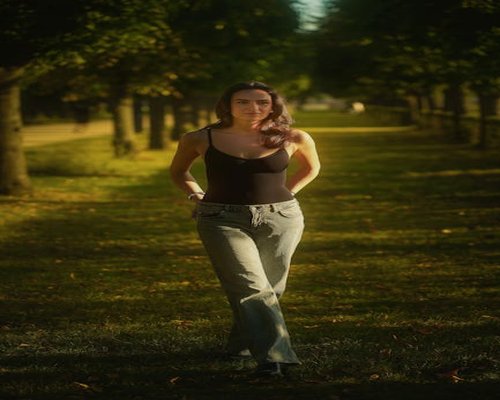 A woman walking comfortably in a sunlit city park